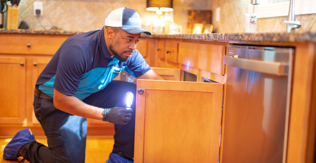 ZPLUMBERZ franchise owner looking under sink for problems